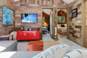 a living room with a red cabinet and a tv at Sydneys River Retreat in Guerneville
