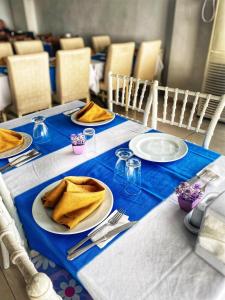 a table with plates and napkins on top at Deniz Hotel in Büyükçekmece