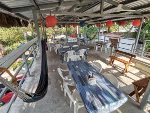 a patio with a blue table and chairs and red lanterns at Hotel y Restaurante Rincón Familiar in La Libertad