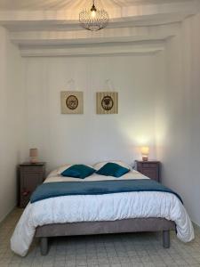 een slaapkamer met een groot bed met blauwe kussens bij Gîte les Tilleuls in Le Guédéniau