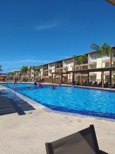 - une grande piscine bleue avec des personnes dans l'établissement Apart Resort Beira Mar Mutá - PS, à Porto Seguro