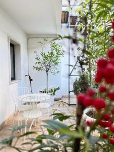 un patio con mesa, sillas y un árbol en Imago Plus Hotel, en Bari