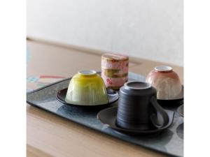 a tray with plates and vases on a table at Hotel Rashiku Kanazawa - Vacation STAY 49686v in Kanazawa