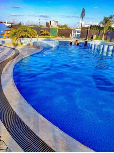 a large blue swimming pool with people in it at La Maison II- Two Bedroom in Tatu City, Nairobi in Nairobi