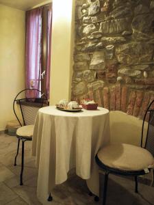 una mesa blanca con 2 sillas y una pared de piedra en Pietre di Mare, en Monterosso al Mare