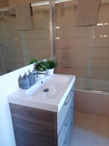 a bathroom with a white sink and a tub at La casa del Navegante in Miramar