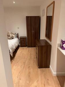 a bedroom with a bed and a dresser and a mirror at 010- Lovely one bedroom in Ealing F6 in Ealing