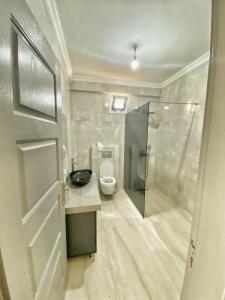 a bathroom with a toilet and a walk in shower at Deniz Hotel in Büyükçekmece
