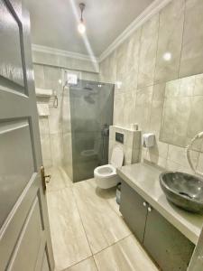 a bathroom with a toilet and a sink and a shower at Deniz Hotel in Büyükçekmece