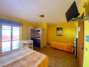 a hotel room with two beds and a flat screen tv at Residence Hotel Felix in Ricadi