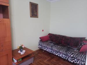 a living room with a zebra print couch and a table at Кульпарківська 128,економ in Lviv