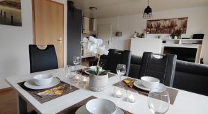 una mesa de comedor con vasos y platos blancos. en diemelseeholiday romantisches Ferienhaus im Sauerland Nähe Willingen Winterberg en Diemelsee