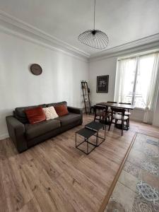 un soggiorno con divano e tavolo di Cosy appartement entre Paris et Disneyland a Le Perreux-sur-Marne
