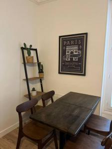 comedor con mesa de madera y sillas en Cosy appartement entre Paris et Disneyland, en Le Perreux-Sur-Marne