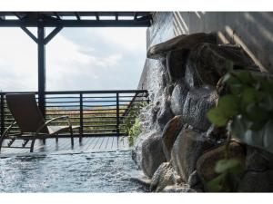 東広島市にあるHotel Areaone Hiroshima Wing - Vacation STAY 62250vの石壁のパティオ(椅子付)