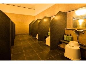 Hotel Areaone Hiroshima Wing - Vacation STAY 62250v في هيغاشيهيروشيما: حمام مع صف من الأكشاك مع المراحيض