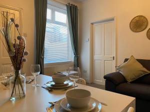 a living room with a table with plates and wine glasses at Kitchener - Wonderful 2-Bedroom Apt Sleeps 5 Free Parking Free WiFi in Gateshead