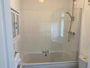 uma casa de banho com um chuveiro e uma banheira em Kitchener - Wonderful 2-Bedroom Apt Sleeps 5 Free Parking Free WiFi em Gateshead