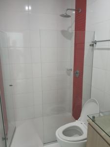 a bathroom with a white toilet and a shower at Hermoso apartamento con piscina frente al mar - Primera Ensenada in Coveñas +9 photos