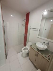 a bathroom with a toilet and a sink and a mirror at Hermoso apartamento con piscina frente al mar - Primera Ensenada in Coveñas