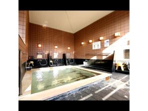 Una gran piscina de agua en un baño con sillas en IyashinoYado Akariya - Vacation STAY 74806v en Kanayama