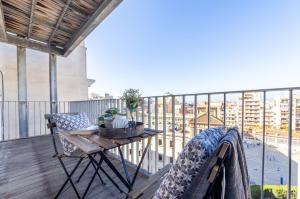 a balcony with a table and chairs and a view of a city at WOOOW!!! Àtic Cèntric amb Terrassa in Tarragona