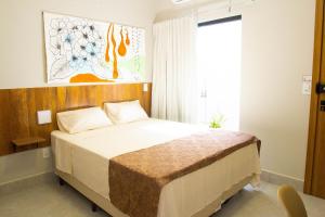 a bedroom with a bed and a large window at Fiori Suítes in Goiânia