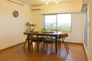 uma sala de jantar com uma mesa e cadeiras e uma janela em Seacore Villa - Vacation STAY 14248 em Ishigaki