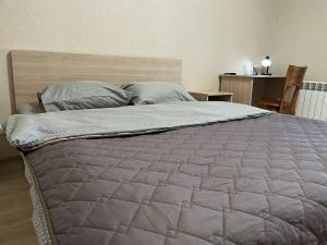 een slaapkamer met een groot bed met een houten hoofdeinde bij FOX Rooms 90 in Nikolayev