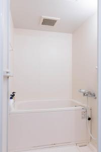 uma casa de banho com uma parede branca e um lavatório. em Seacore Villa - Vacation STAY 14248 em Ishigaki