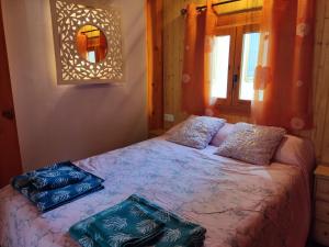 a bedroom with a bed with two pillows on it at Apartamento El Grifo in Carmona