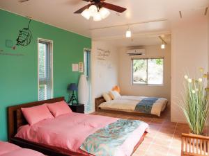 - une chambre avec 2 lits et un ventilateur de plafond dans l'établissement MILLEFY's HOUSE - Vacation STAY 14247, à Ishigaki