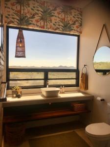 ein Badezimmer mit einem Waschbecken und einem großen Fenster in der Unterkunft LEOPARD'S VIEW MOUNTAIN VILLA @ Steinheim Game Farm & Camping in Prospect