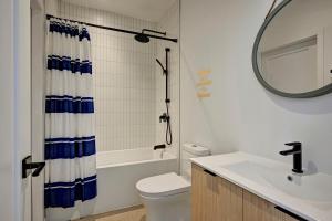 a bathroom with a toilet and a sink and a mirror at Amazing 1Bedroom Great Location presented by TripMontreal in Montreal