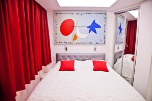 a bedroom with a bed with red curtains at Cura Sol in Playa del Cura