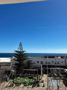 Un grupo de mesas y sillas frente a un edificio. en Skøn lejlighed med havudsigt og tæt på stranden, en Torreguadiaro