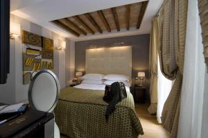 a bedroom with a large bed and a mirror at Duca d'Alba Hotel - Chateaux & Hotels Collection in Rome