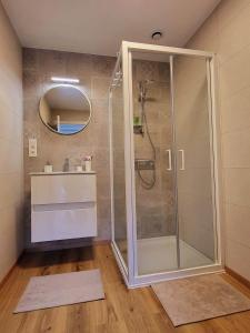 a shower with a glass door in a bathroom at Gîte Le Haut des Vannes in Neufchâteau