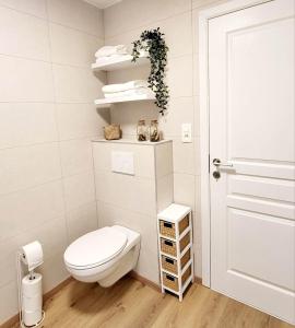 a small bathroom with a toilet and a door at Gîte Le Haut des Vannes in Neufchâteau