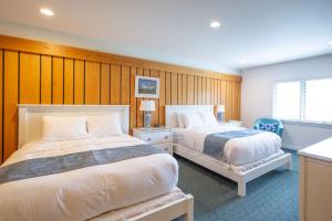 a hotel room with two beds and a window at The Leland Lodge 