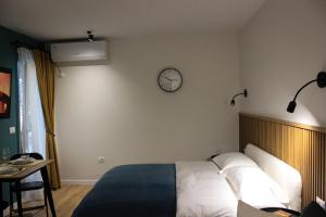 1 dormitorio con 1 cama y reloj en la pared en Studio in Tirana en Tirana