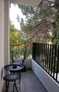 Un balcón con una mesa y dos taburetes. en Studio in Tirana en Tirana