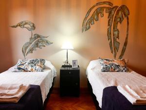 um quarto com 2 camas e uma mesa com um candeeiro em Calchaquíes Home Hostel em San Salvador de Jujuy
