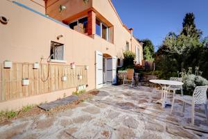a patio with a table and chairs next to a building at La farigoulette in Rayol-Canadel-sur-Mer +2 photos