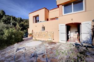 a table and chairs in front of a house at La farigoulette in Rayol-Canadel-sur-Mer