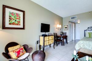 a hotel room with a bed and a dining room at Pirates Bay B206 in Fort Walton Beach
