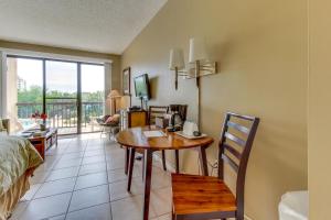 a living room with a table and a room with a bed at Pirates Bay B206 in Fort Walton Beach