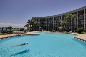 a woman laying in a swimming pool in a hotel at Pirates Bay B206 in Fort Walton Beach
