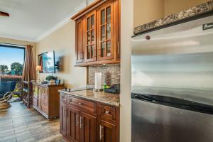 a kitchen with wooden cabinets and a stainless steel refrigerator at Pirates Bay A113 in Fort Walton Beach