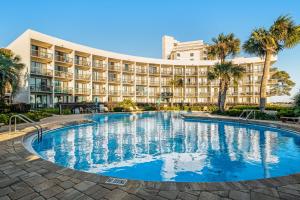 a hotel with a large swimming pool in front of a building at Pirates Bay A113 in Fort Walton Beach